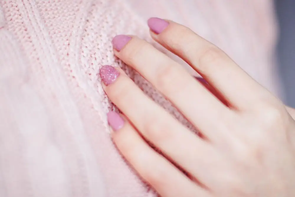 Uñas rosas de acabado brillante sobre tejido suave