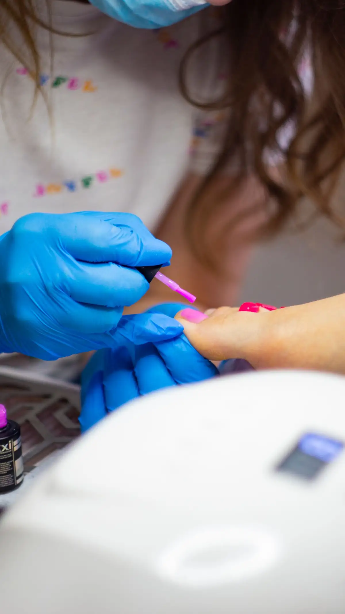 Aplicación de esmalte en gel rosa durante un pedicure spa
